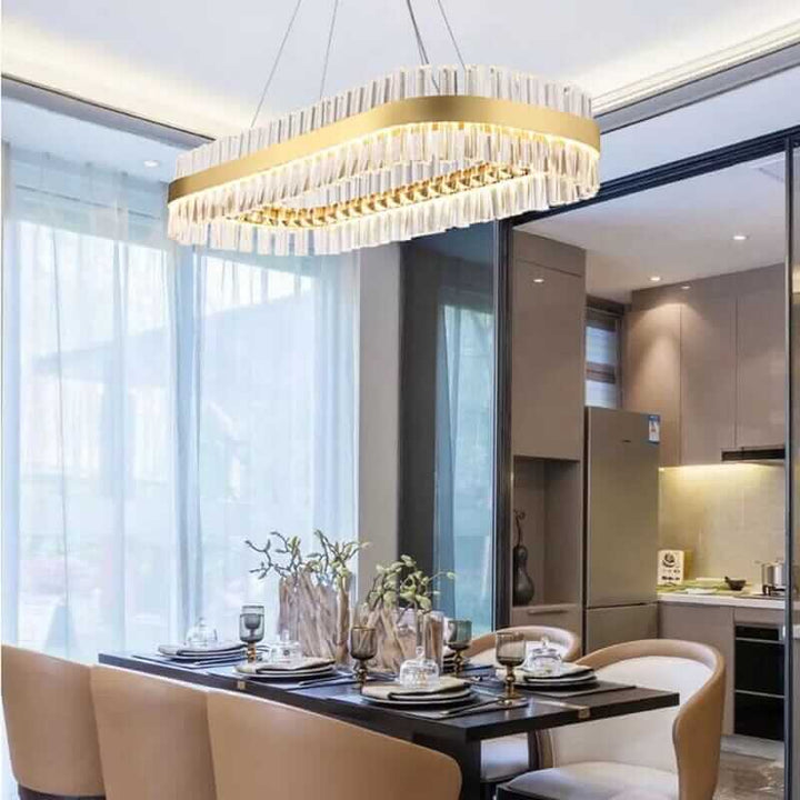 Elegant gold crystal chandelier illuminating a modern dining space, showcasing timeless sophistication and style.