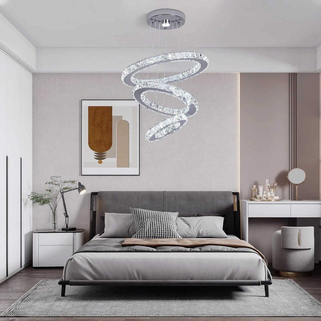 Stylish entryway chandelier illuminating a modern bedroom with sophisticated decor and cozy bedding.
