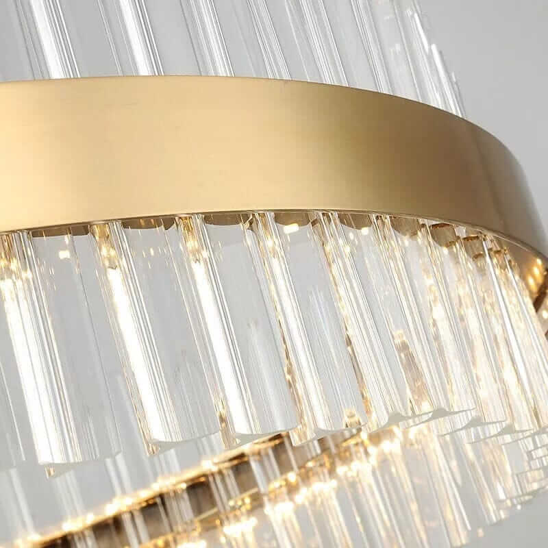 Close-up of a gold crystal chandelier showcasing elegant stainless steel and clear glass elements, illuminating with sophistication.