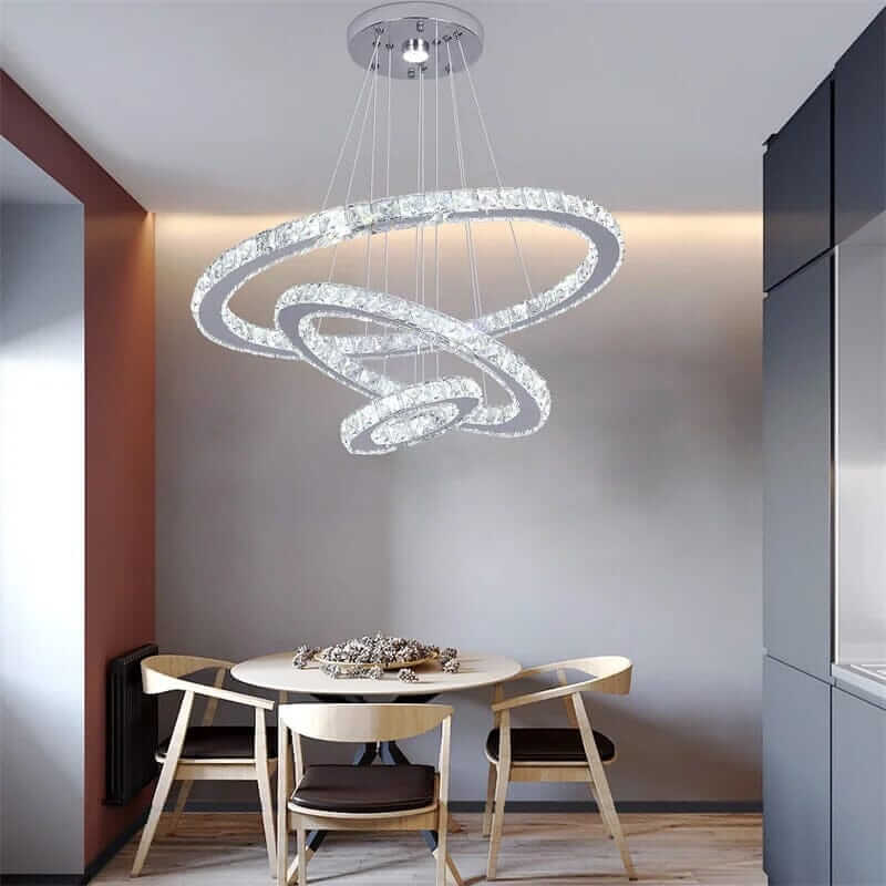 Stylish entryway chandelier with three interlocking rings and a modern design, illuminating a cozy dining area.