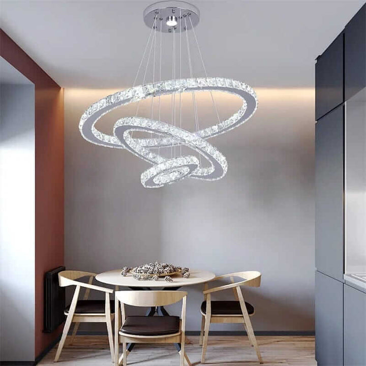 Stylish entryway chandelier with three interlocking rings and a modern design, illuminating a cozy dining area.