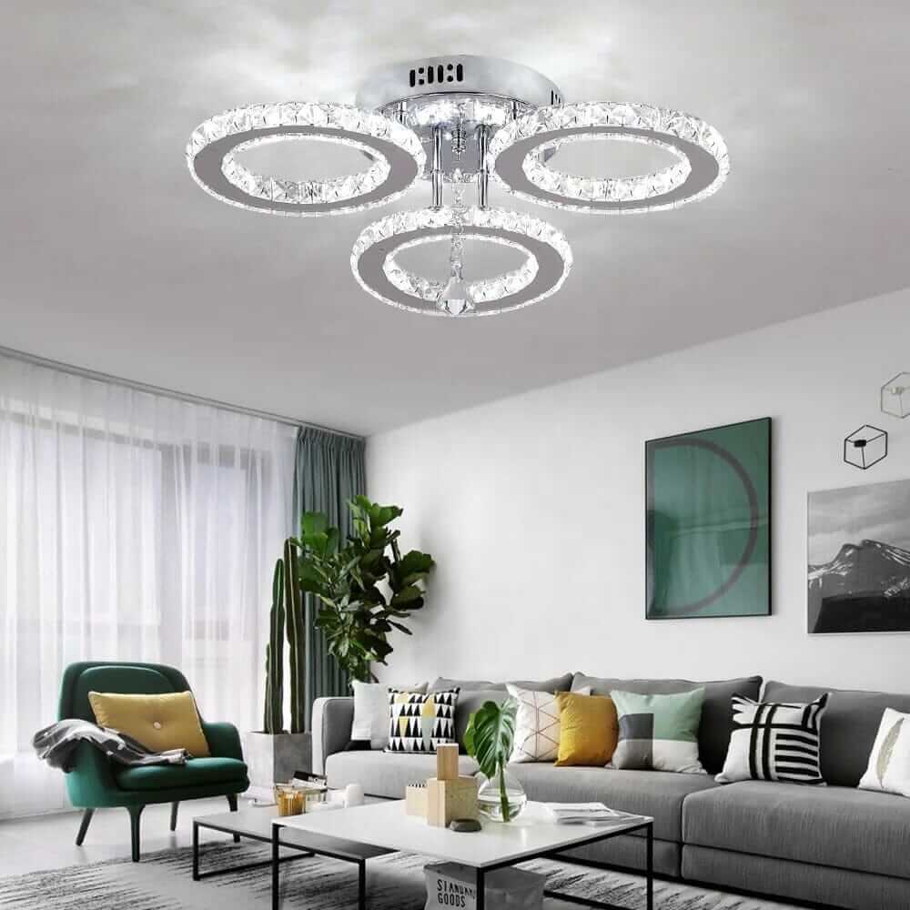 Small crystal chandelier with three circular tiers illuminating a modern living room.