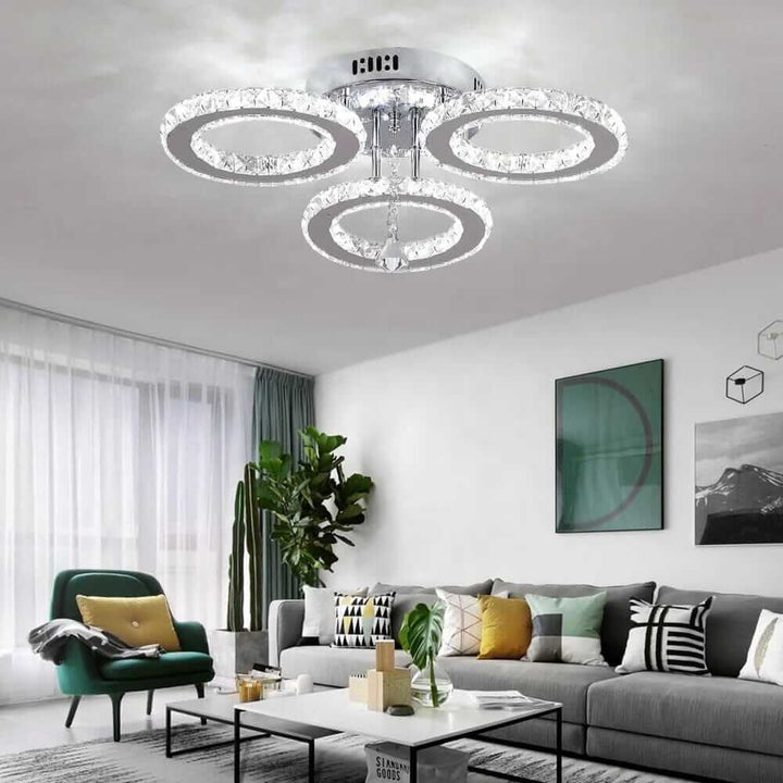Small crystal chandelier with three circular tiers illuminating a modern living room.