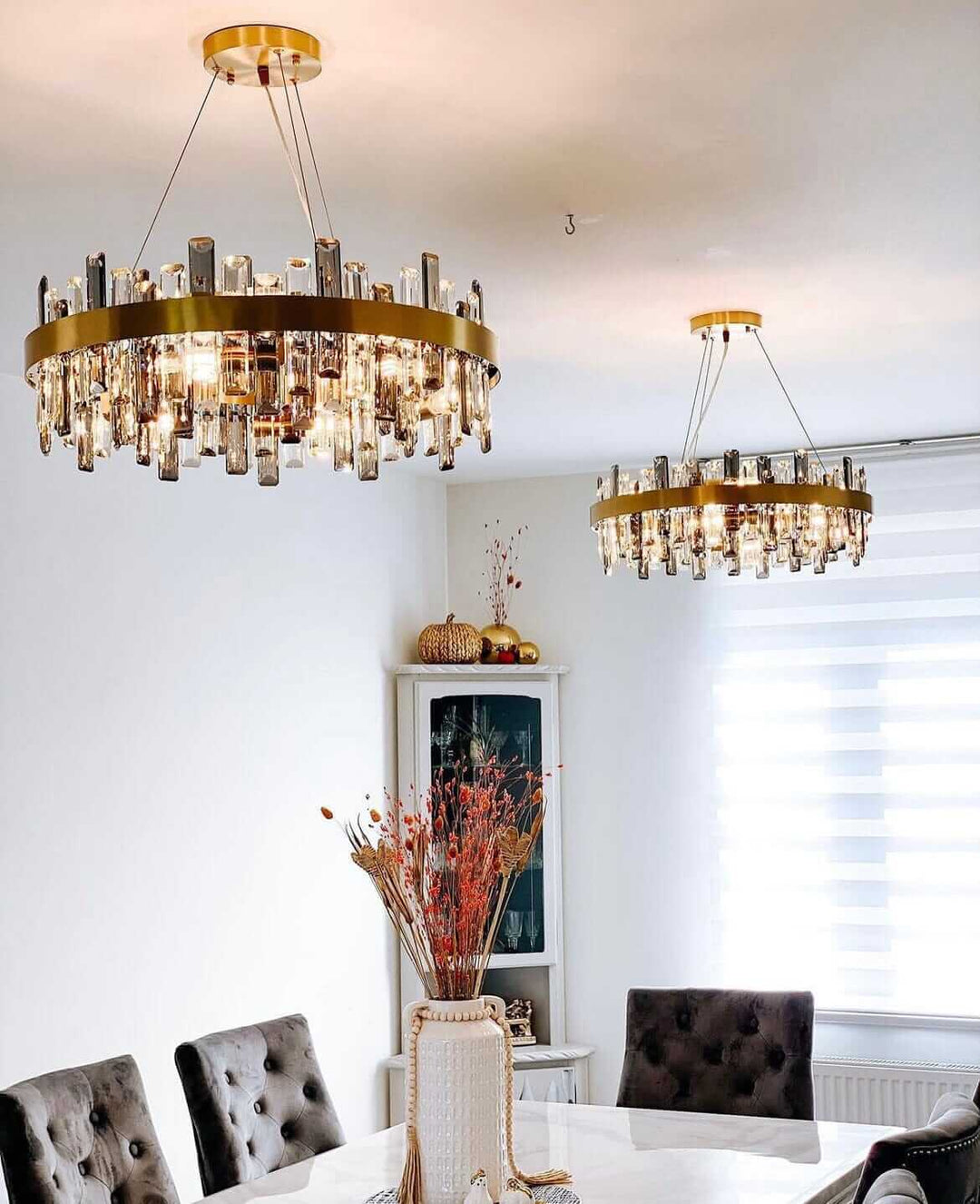 Gold crystal chandeliers hanging in a modern dining room, showcasing elegance and luxury in design.