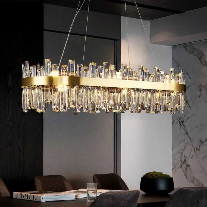 Elegant gold crystal chandelier illuminating a modern dining space with warm light and stylish design.