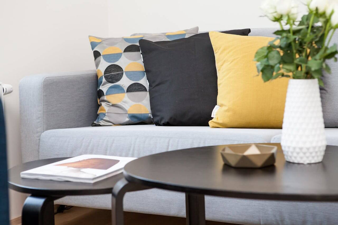 A cozy living room showcasing stylish coffee tables with decorative pillows and flowers, emphasizing creative uses for coffee tables.