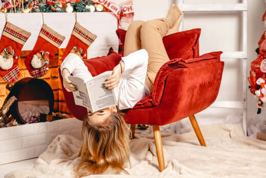 Comfortable armchair in a cozy setting with a person reading a book for relaxation and comfort.