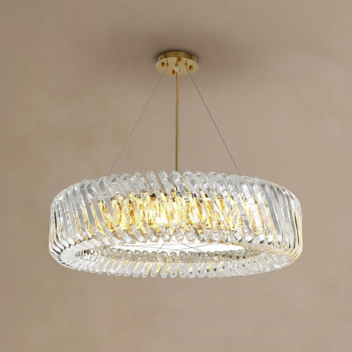 Chandelier with clear glass shade and gold accents on a beige background