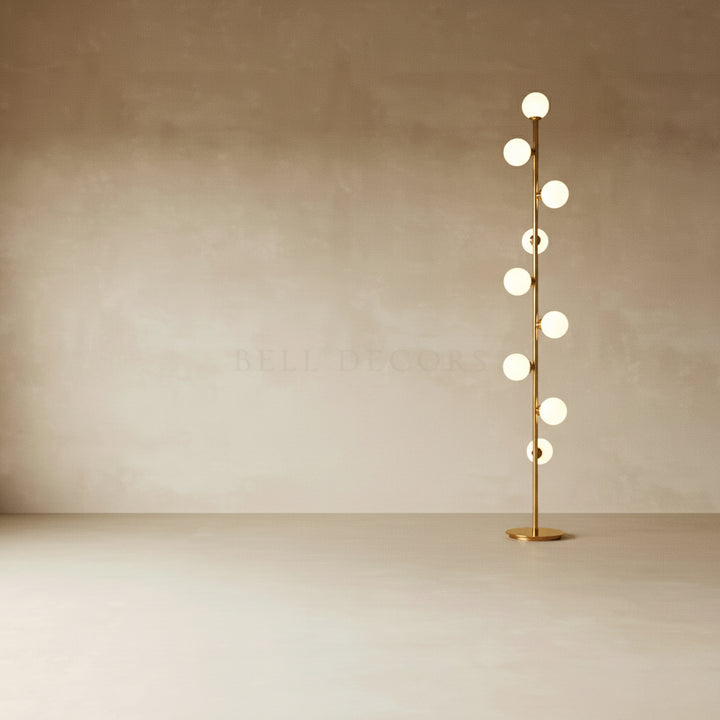 Modern floor lamp with multiple spherical lights on a plain background