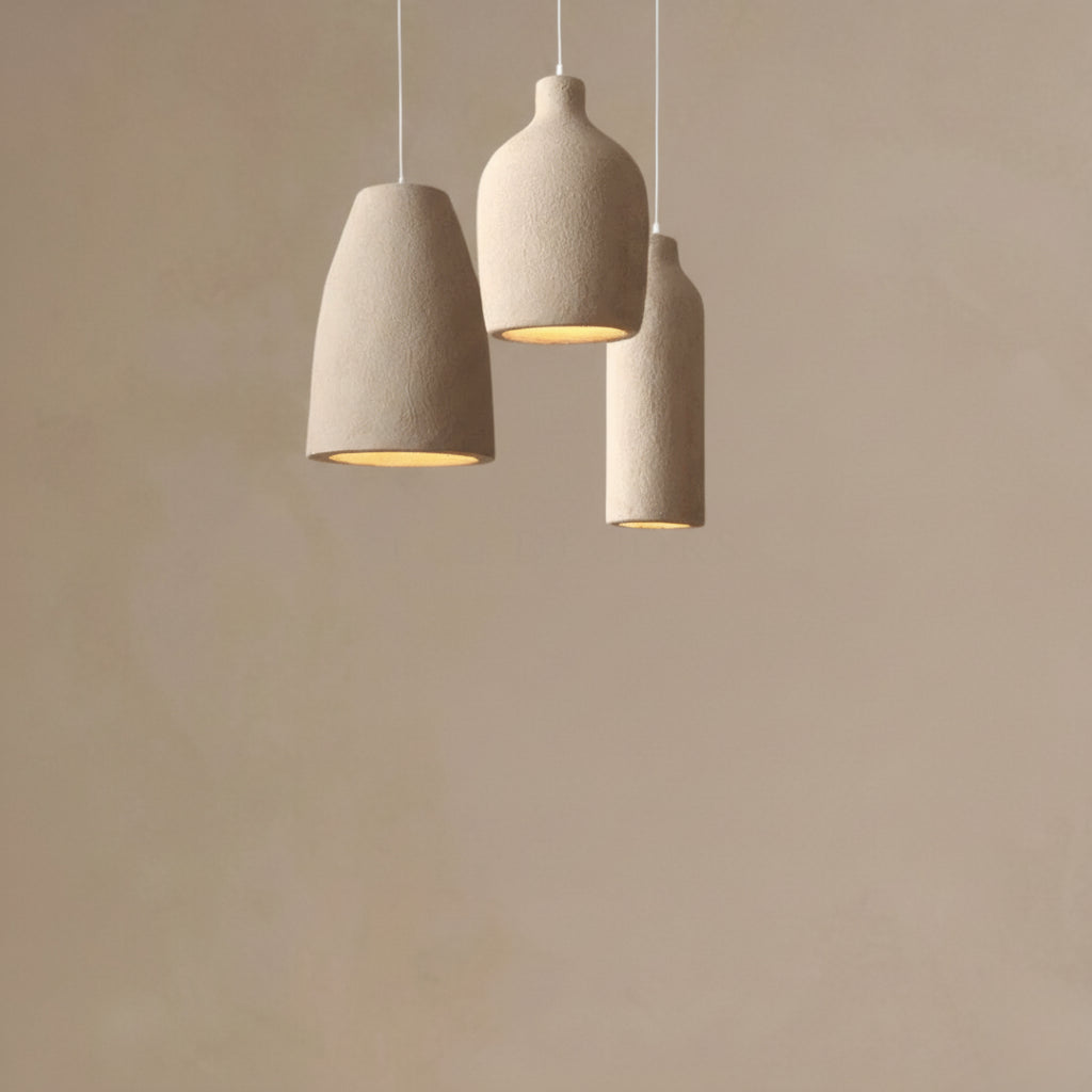 Three beige pendant lights hanging against a beige wall
