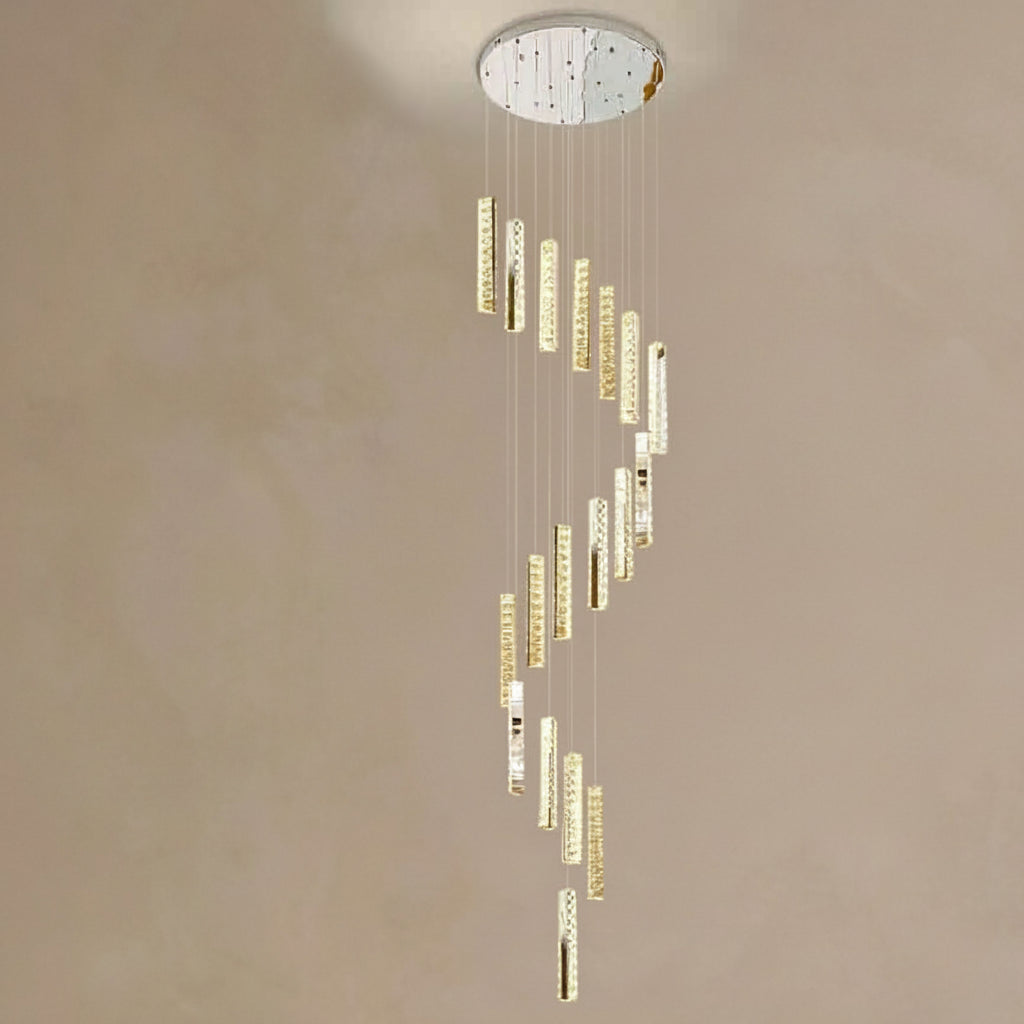 Modern chandelier with gold and crystal accents on a beige wall.