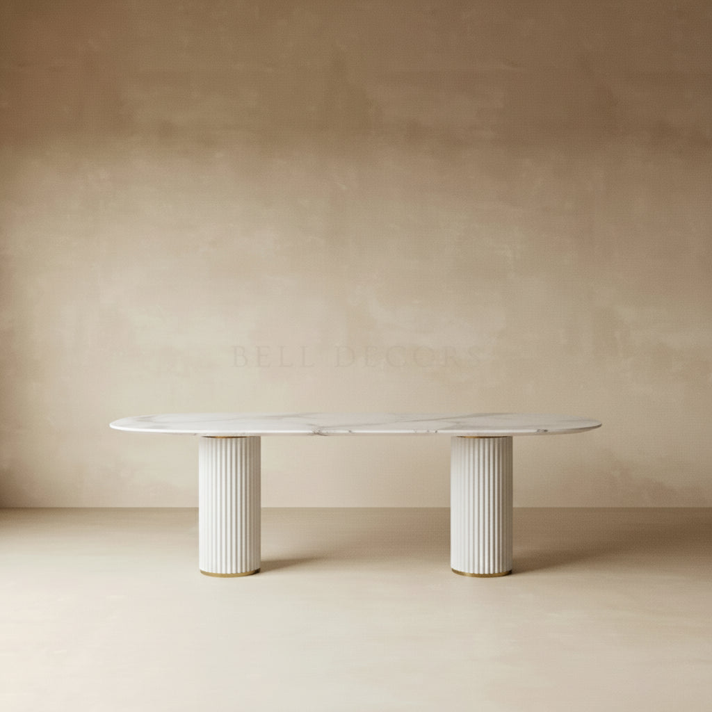 White marble dining table with fluted columns against a beige wall.