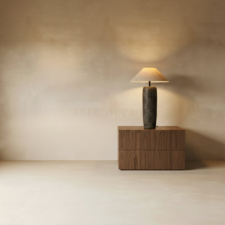 Modern table lamp on a wooden side table against a beige wall.