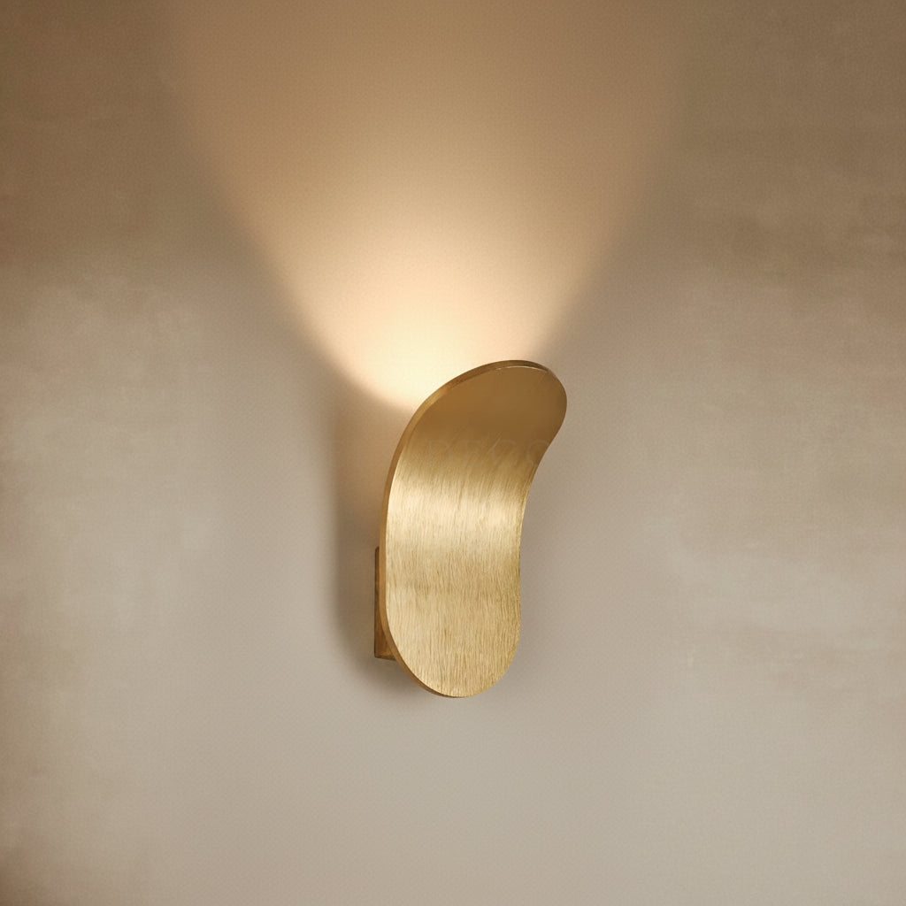 Gold wall sconce on a beige wall