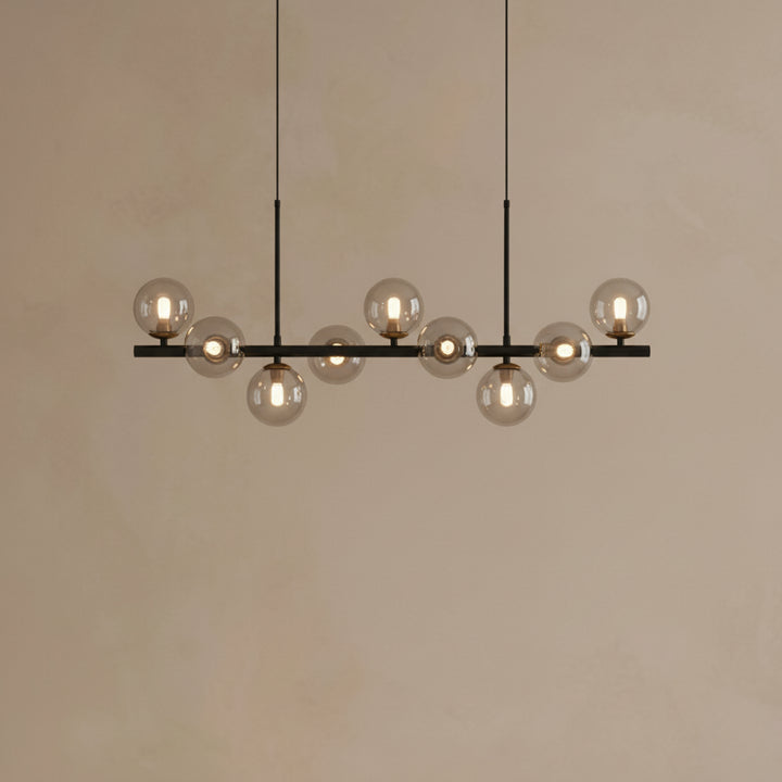 Modern chandelier with multiple glass bulbs on a plain wall