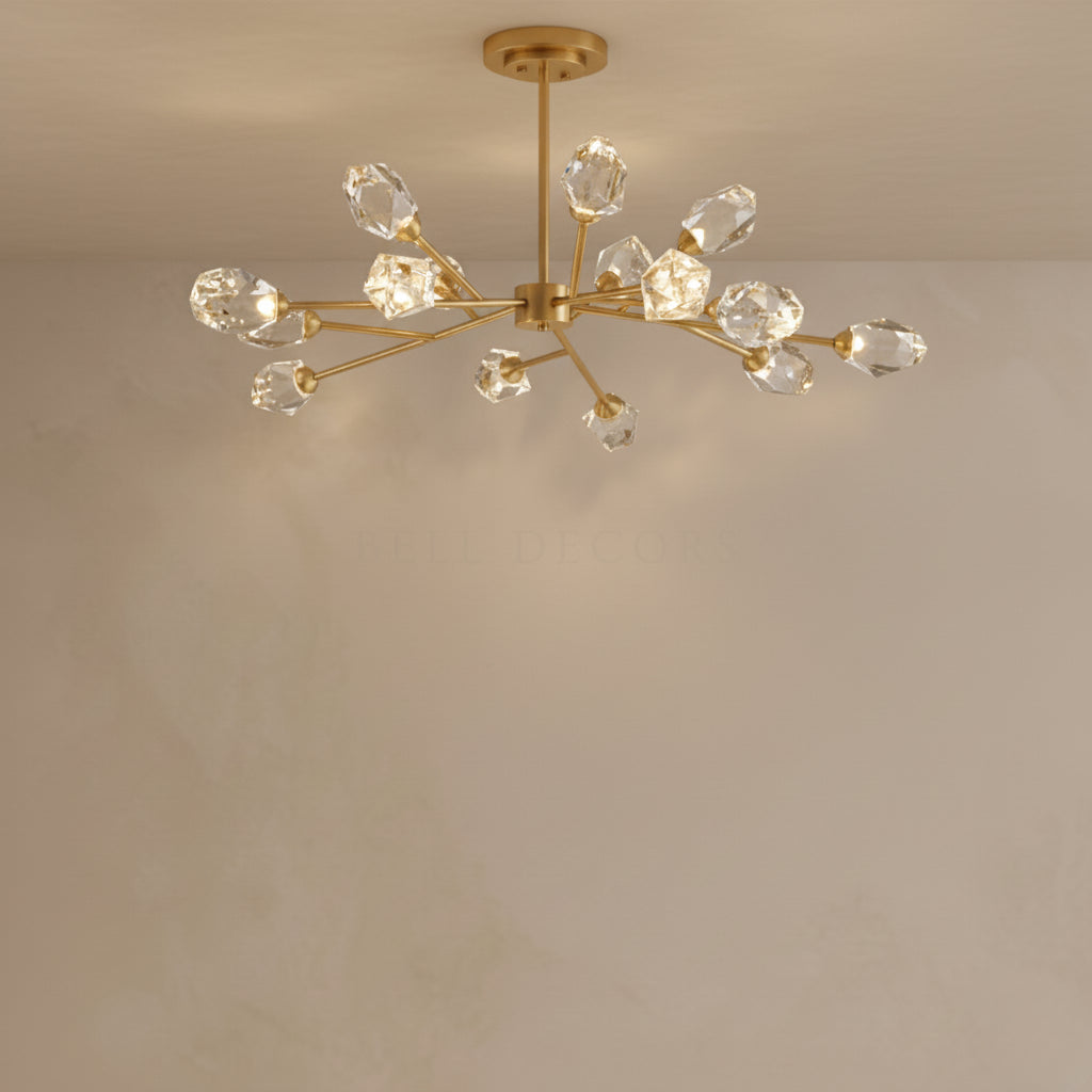 Gold chandelier with crystal-like glass shades on a beige wall.