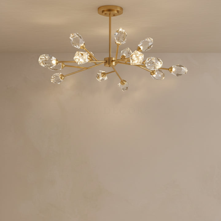 Gold chandelier with crystal-like glass shades on a beige wall.