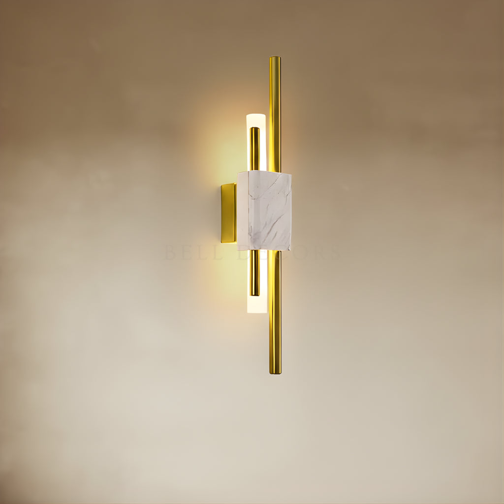 Gold wall sconce with marble accent on a beige wall