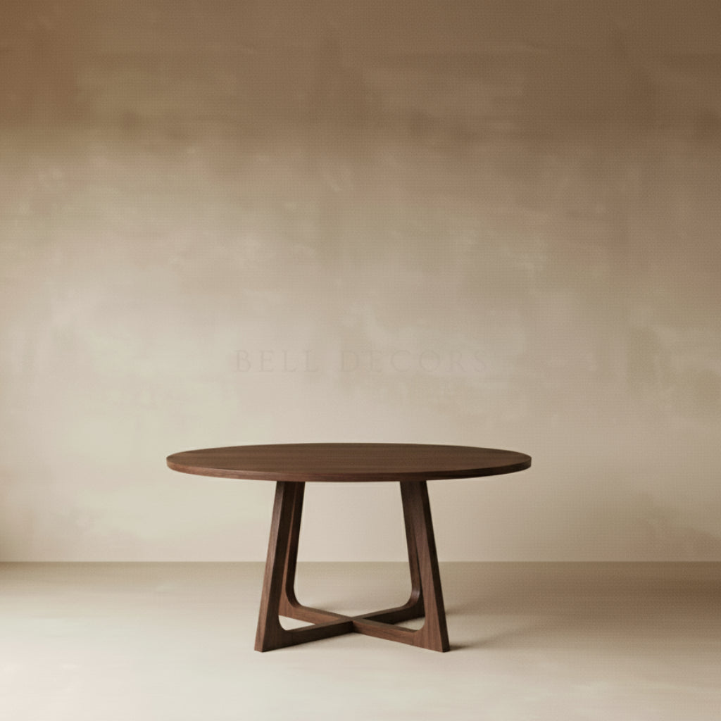 Round wooden table with a minimalist design against a plain wall.