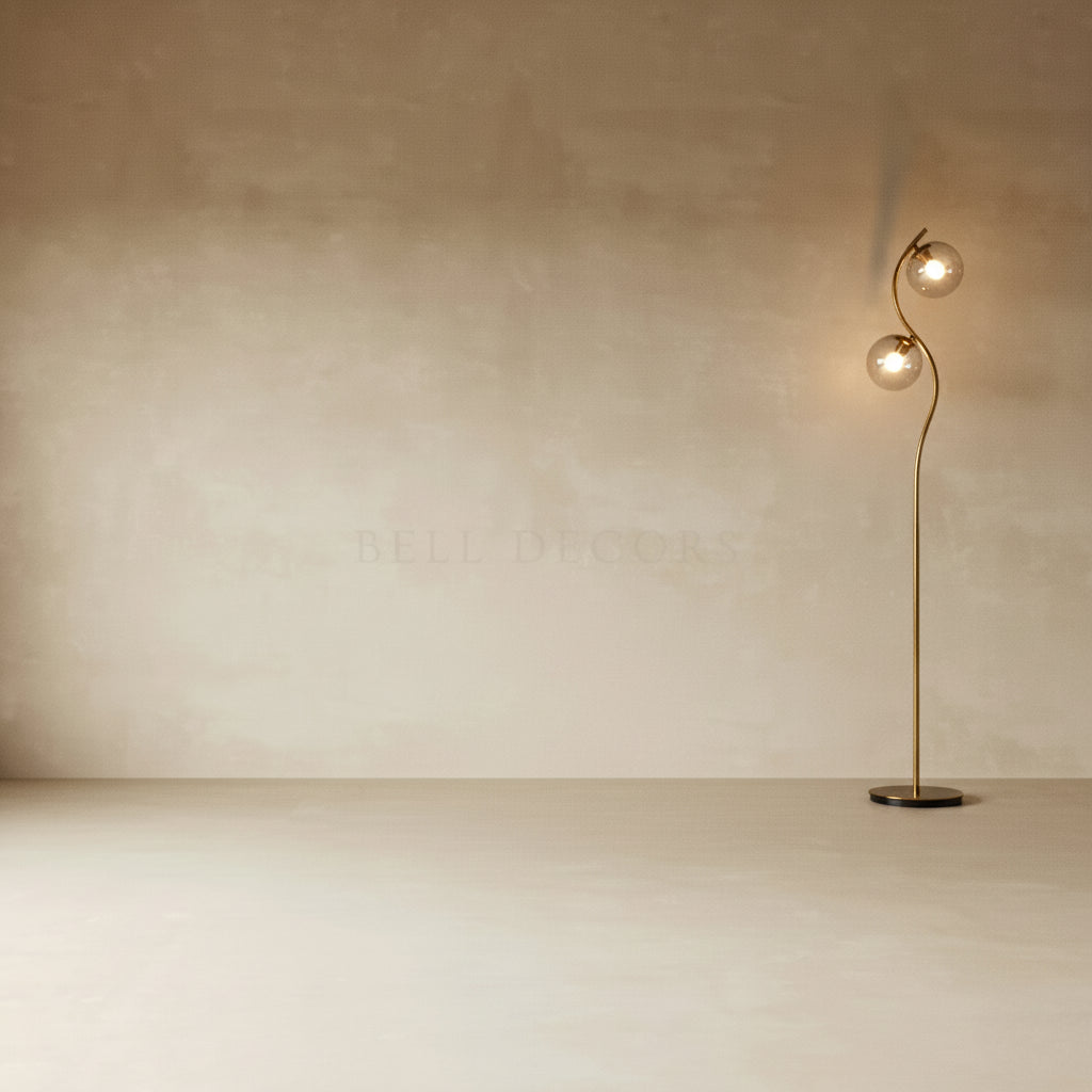 Modern floor lamp with two spherical lights against a plain wall.