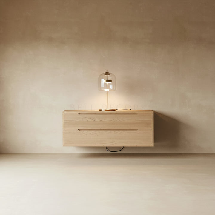 Wooden drawer unit with a lamp on a beige wall