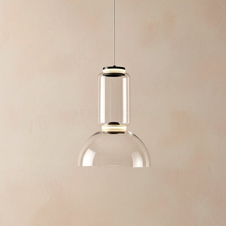 Clear glass pendant light against a beige wall