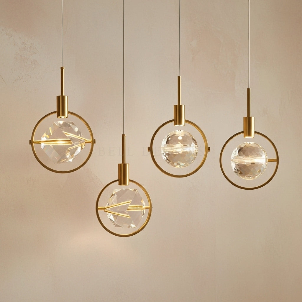 Four modern pendant lights with gold fixtures and clear glass globes on a neutral background.