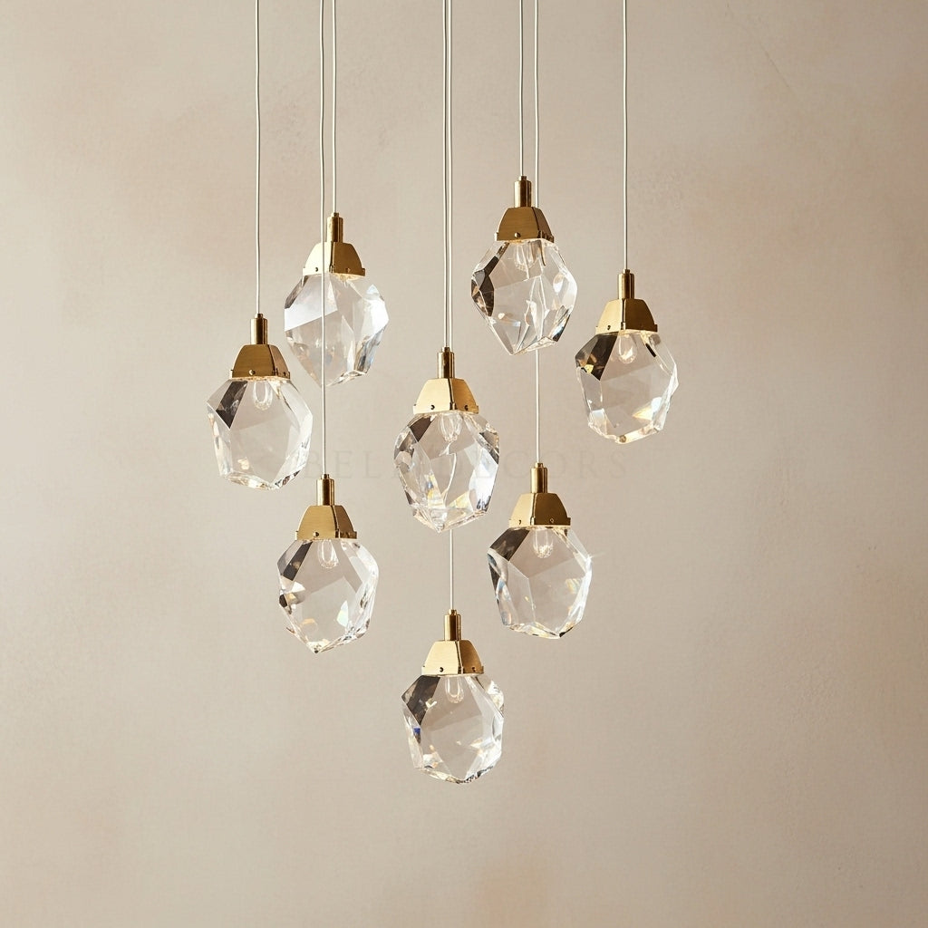 Set of crystal pendant lights with gold accents on a neutral background