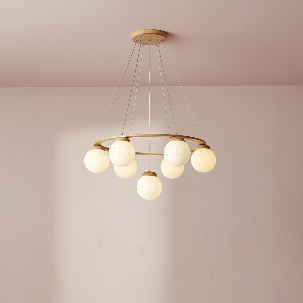 Modern chandelier with gold frame and white bulbs on a plain wall.