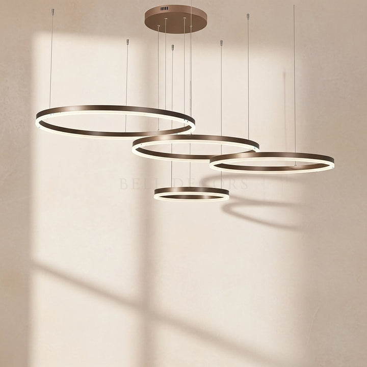 Set of four circular pendant lights on a neutral background