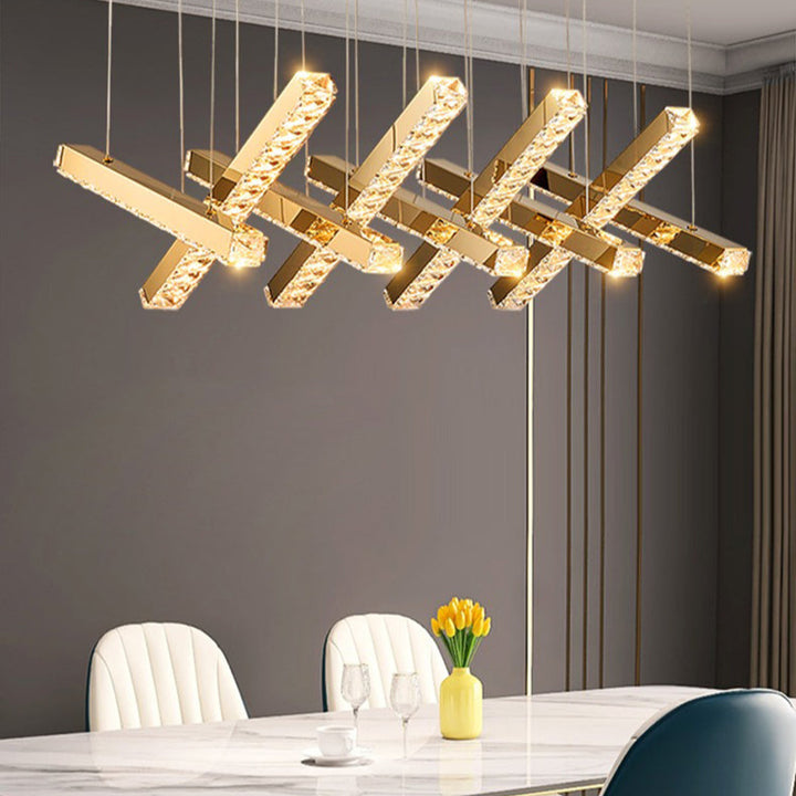 Modern gold pendant light fixture in a dining room setting.