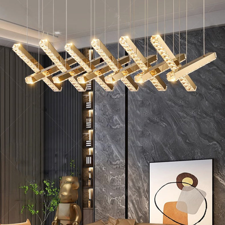Modern living room with a gold chandelier, brown sofa, and decorative wall art.