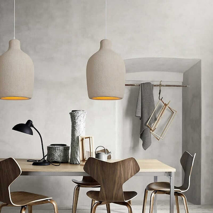 Wabi Sabi Pendant Light illuminating a modern dining space with wooden chairs and minimalist decor.