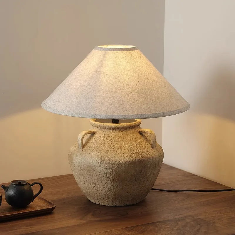 Mid Century Table Lamp - Imperfect Beauty with soft glow emanating from a pottery base and fabric shade.