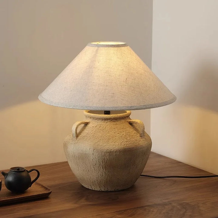 Mid Century Table Lamp - Imperfect Beauty with soft glow emanating from a pottery base and fabric shade.