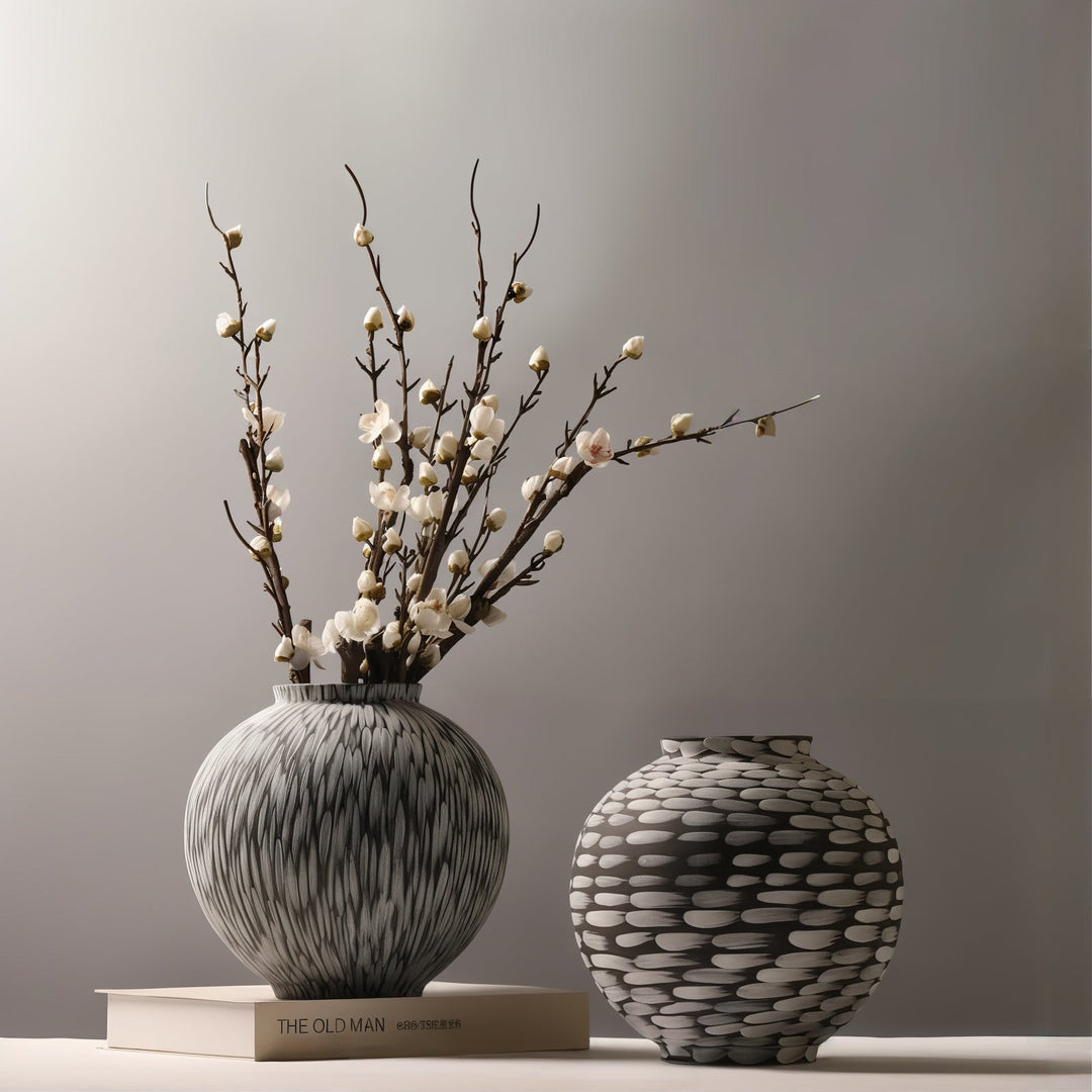 Ceramic Vases - Decorative Vases featuring two artistic vases with floral arrangements on a book.
