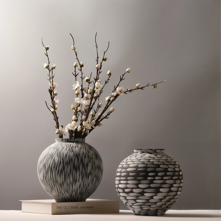 Ceramic Vases - Decorative Vases featuring two artistic vases with floral arrangements on a book.