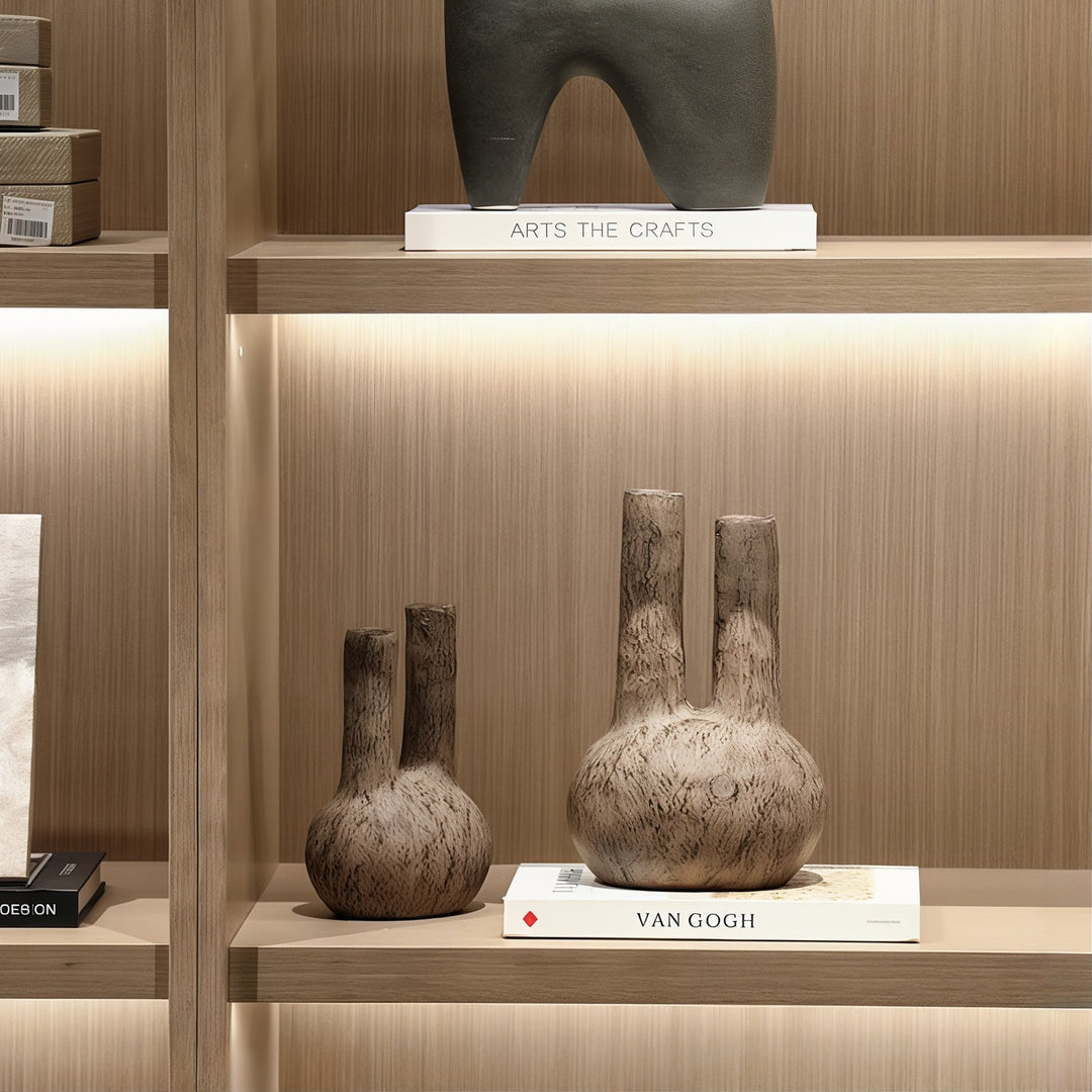 Personal Ornamentation - Brown Ornaments displayed on a wooden shelf with books and decorative items.