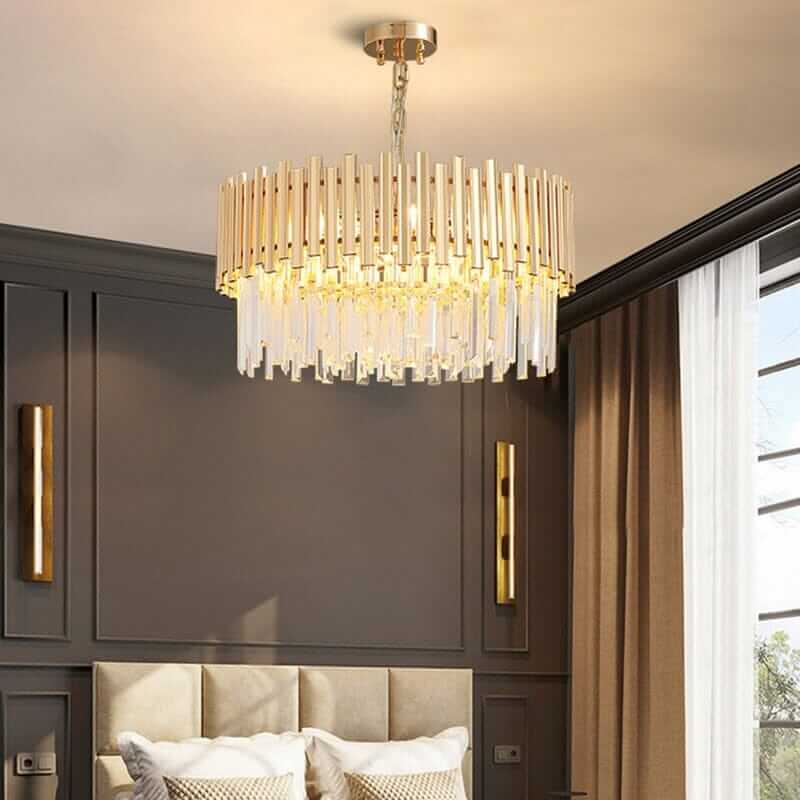 Stylish gold chandelier with crystal accents illuminating a modern bedroom interior.
