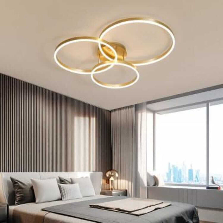 Modern LED chandelier featuring three circular rings, adding elegance to a contemporary bedroom.