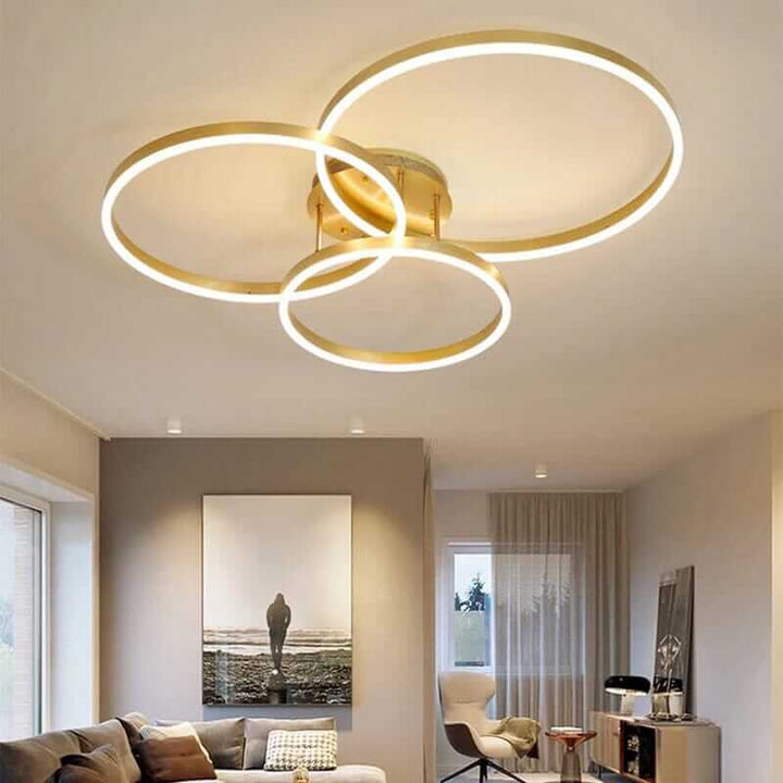 Modern LED chandelier with three circular rings, adding elegance to a contemporary living room.