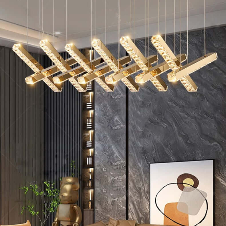Modern living room with a gold chandelier, brown sofa, and decorative wall art.