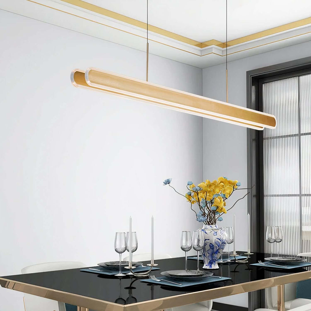 Linear Chandelier - Gold Chandelier illuminating a modern dining table with elegant decor.