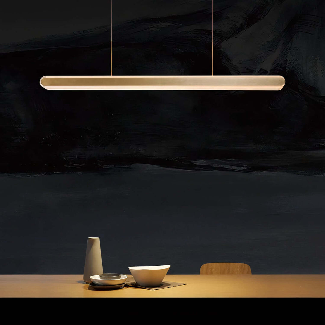 Linear Chandelier - Gold Chandelier illuminating a dining table with elegant minimalism.