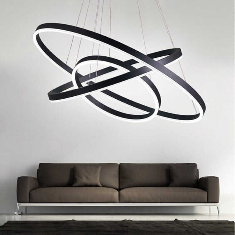 Gold and black chandelier with interconnected rings, enhancing modern living room decor.