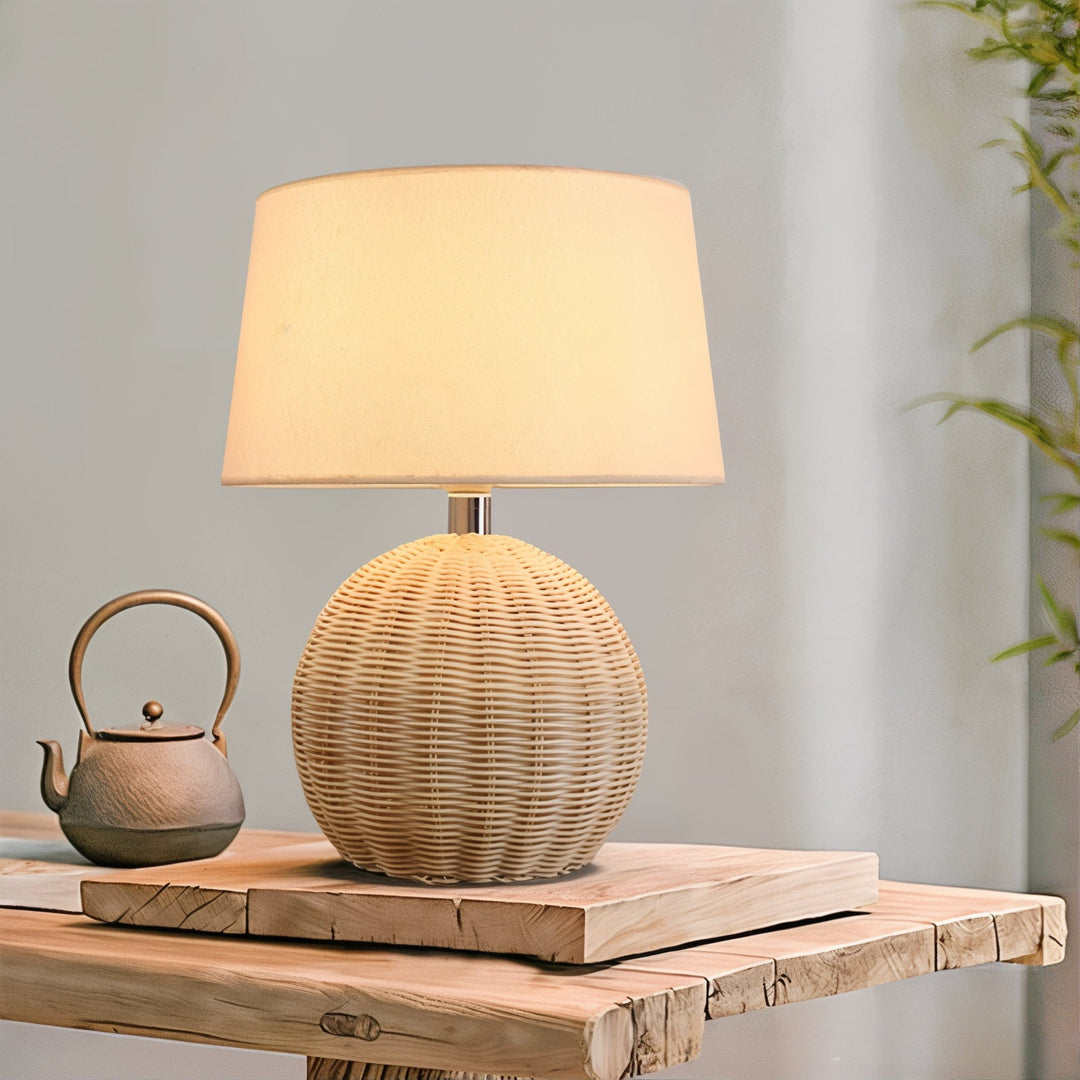 Mid Century Table Lamp - Traditional Yet Contemporary on a wooden table with a teapot, showcasing woven rattan shade.