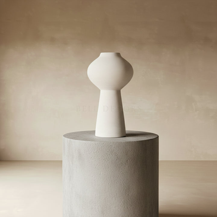 Flower Vase - White Vase displayed on a concrete pedestal against a soft beige background.
