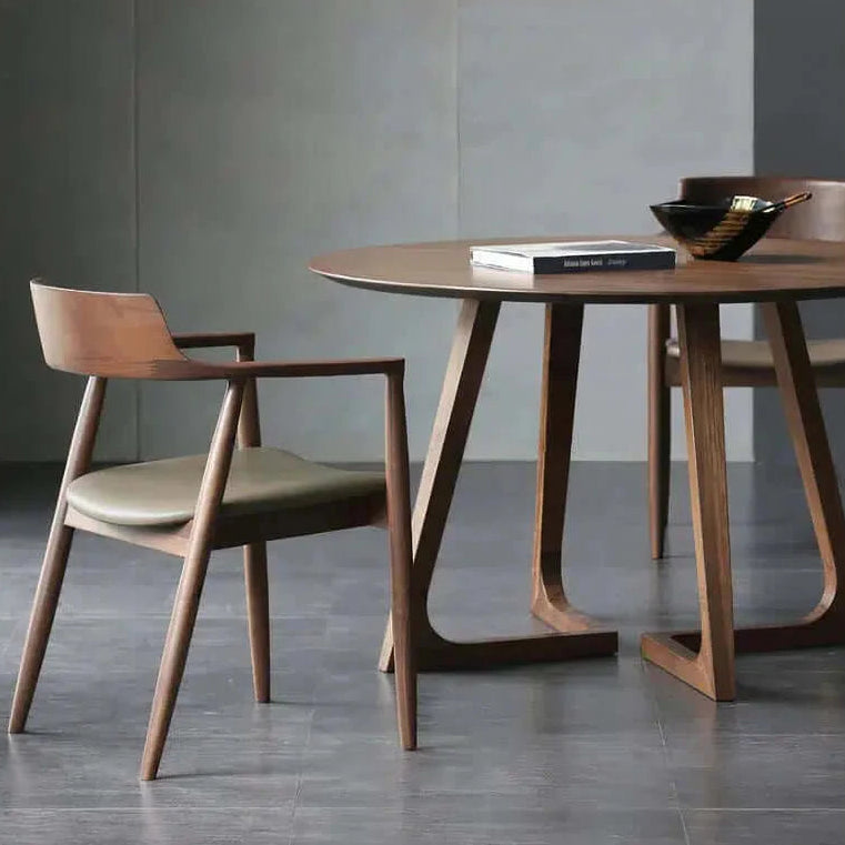 Wood And Leather Chair - For Your Dining Room next to a round dining table with decorative items.